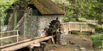 The image shows a watermill and a river